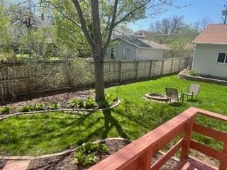 view of yard with a vegetable garden, a fenced backyard, and an outdoor fire pit