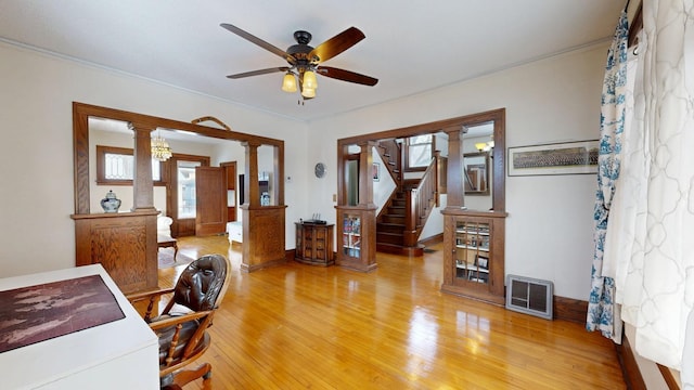 office area featuring a ceiling fan, crown molding, light wood-style floors, ornate columns, and visible vents