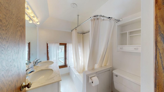 full bathroom featuring toilet, shower / bathtub combination with curtain, double vanity, and a sink
