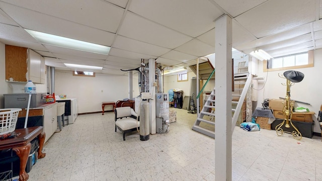 basement featuring stairway, a paneled ceiling, and light floors