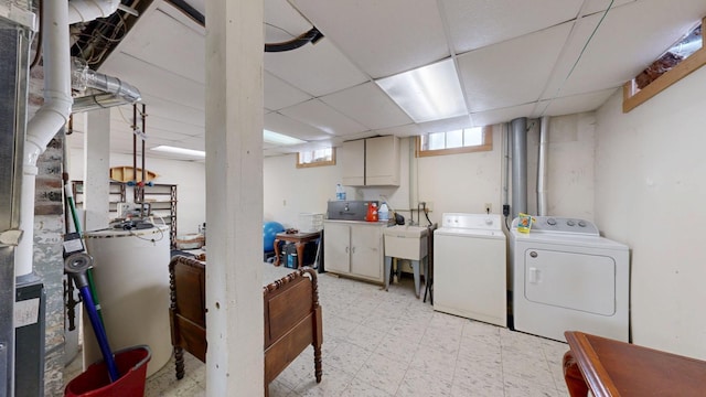 basement with a paneled ceiling, separate washer and dryer, and light floors