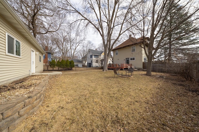 view of yard featuring a deck, a fenced backyard, and a residential view