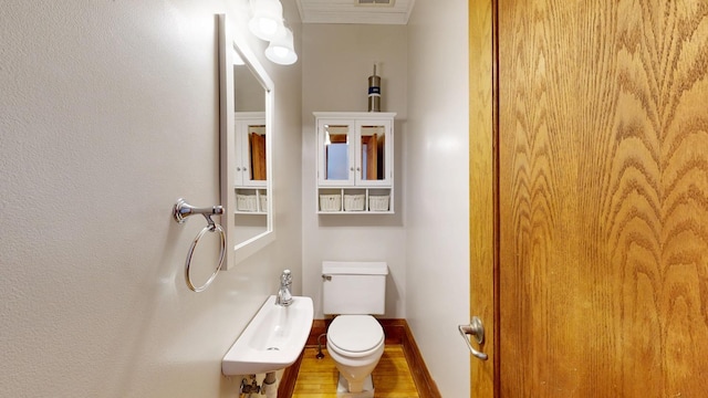 611 5th Ave SW, Rochester, MN 55902 - half bath featuring wood finished floors, toilet, and baseboards