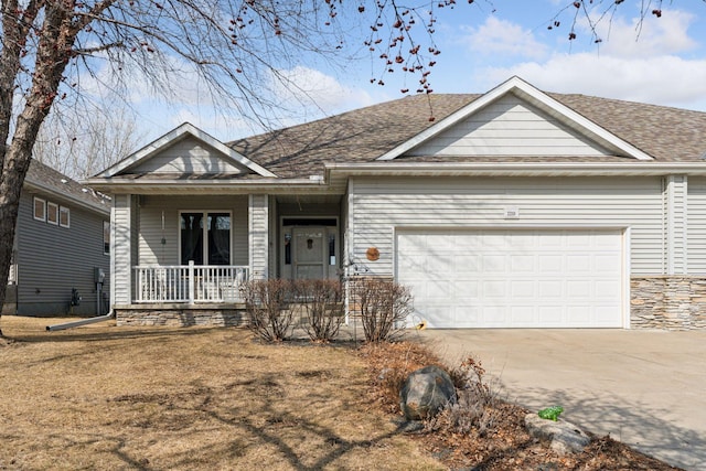 view of front of property with concrete driveway, roof with shingles, covered porch, a garage, and stone siding