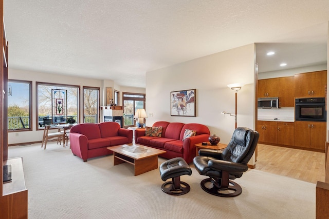 living room with recessed lighting, a textured ceiling, and baseboards