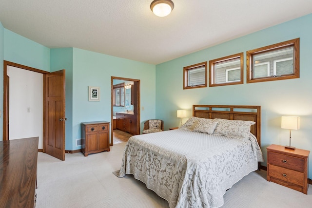 bedroom with light carpet, connected bathroom, and baseboards