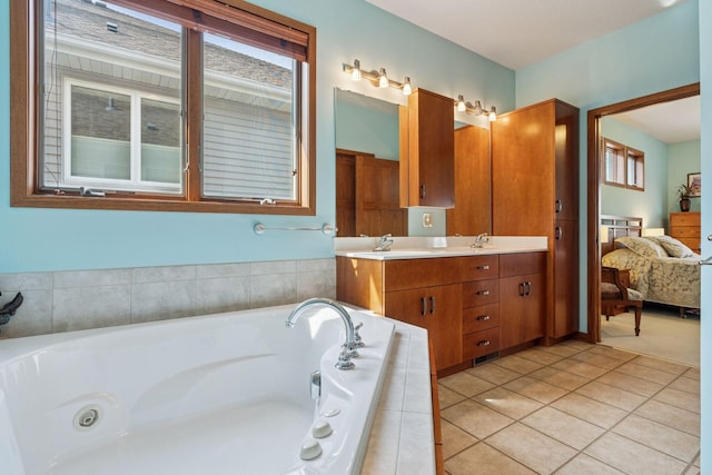 full bath featuring ensuite bath, double vanity, a whirlpool tub, a sink, and tile patterned flooring