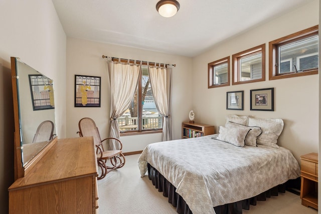 bedroom with light carpet and baseboards