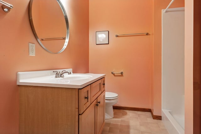 bathroom featuring vanity, toilet, a shower, and baseboards