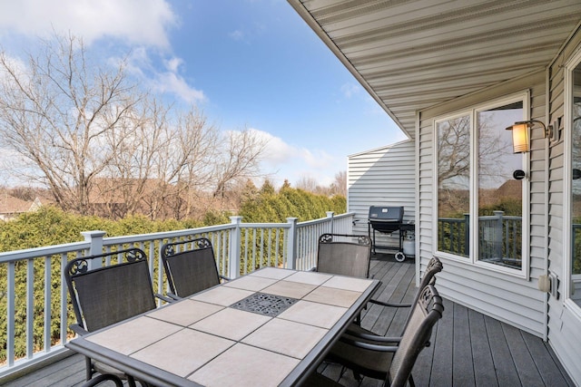 deck with outdoor dining space and grilling area