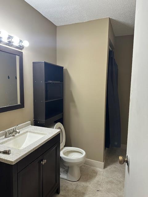 full bathroom featuring toilet, vanity, a shower with curtain, tile patterned floors, and a textured ceiling