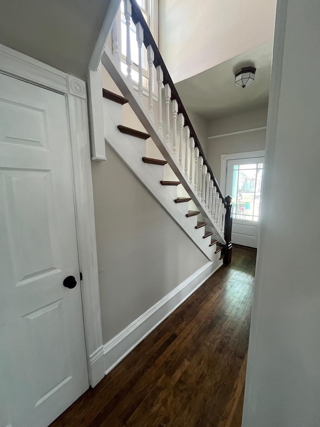 stairs with wood finished floors and baseboards