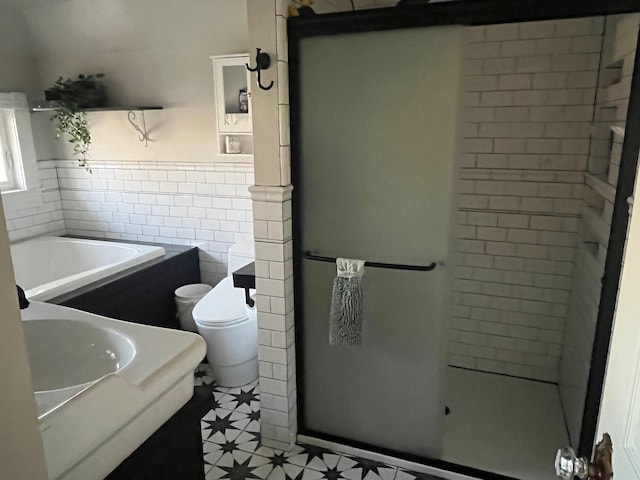 full bathroom featuring vanity, a wainscoted wall, a stall shower, tile walls, and toilet