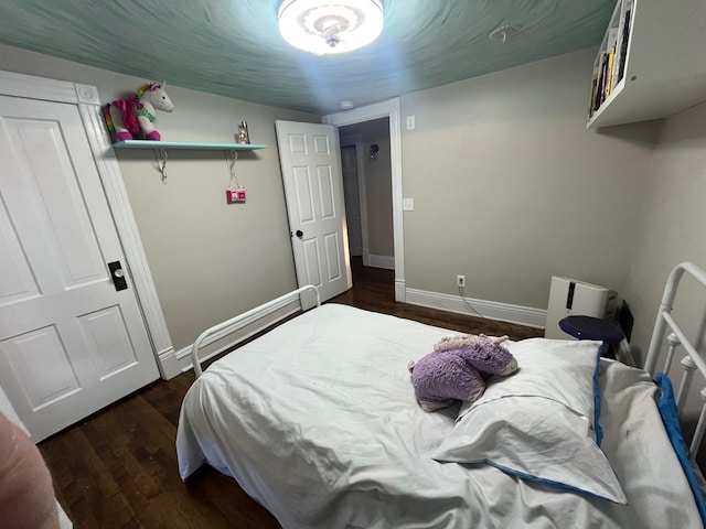 bedroom with dark wood-style floors and baseboards