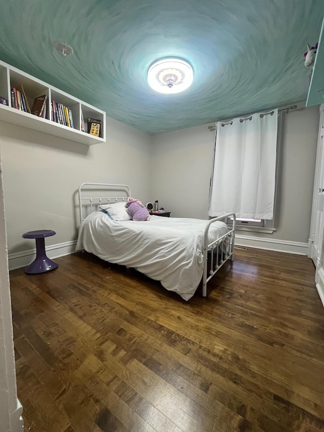 bedroom with baseboards and hardwood / wood-style flooring