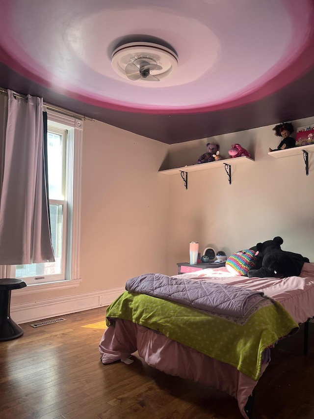 bedroom with visible vents and wood finished floors