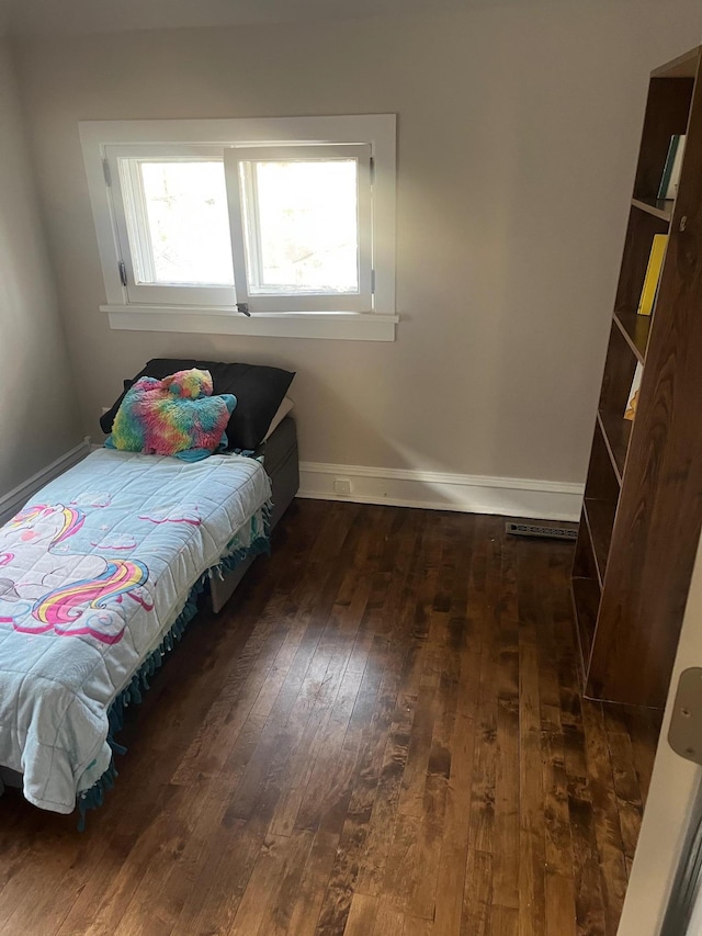 bedroom with baseboards and hardwood / wood-style floors