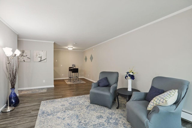 living area with a baseboard heating unit, crown molding, baseboards, and wood finished floors