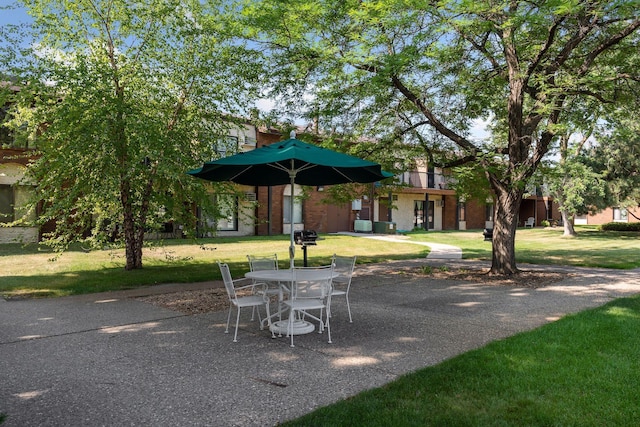 view of community with a patio area and a lawn