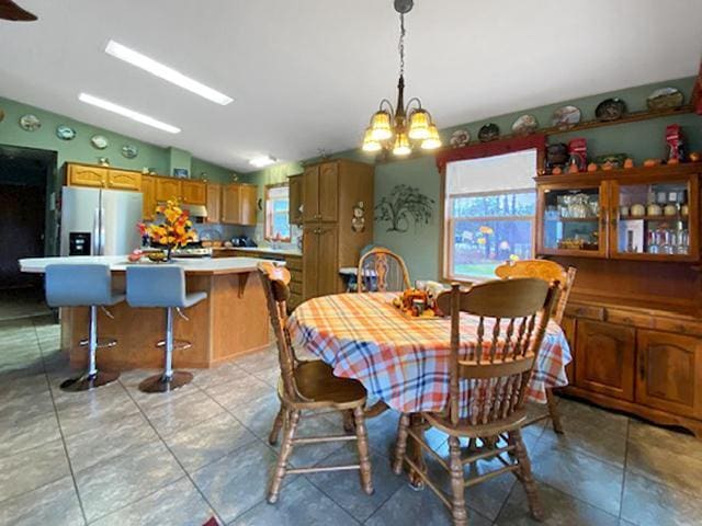 dining room with an inviting chandelier and vaulted ceiling