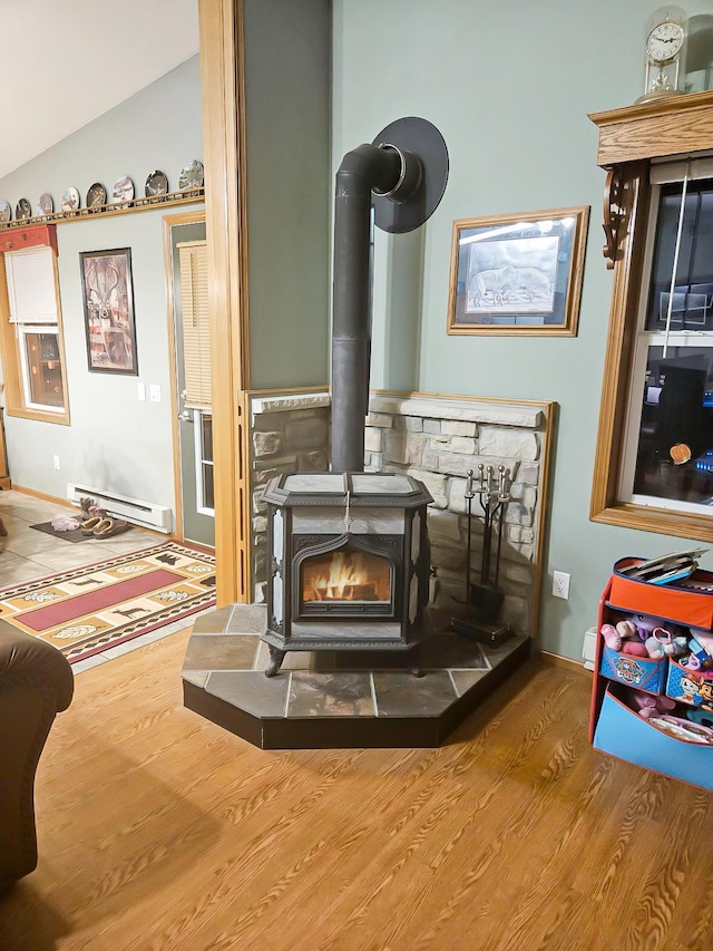 details featuring a baseboard heating unit, a wood stove, and wood finished floors