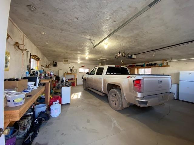 garage featuring a garage door opener and freestanding refrigerator