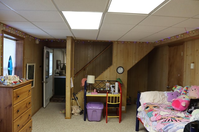 bedroom with a paneled ceiling and wood walls