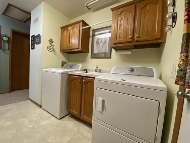 laundry area featuring washer and dryer, baseboards, cabinet space, and a sink