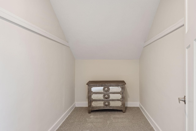 walk in closet with light carpet and lofted ceiling