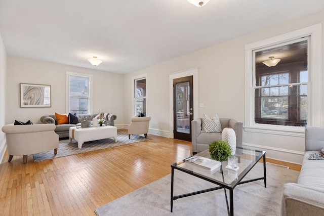 living area with baseboards and light wood finished floors