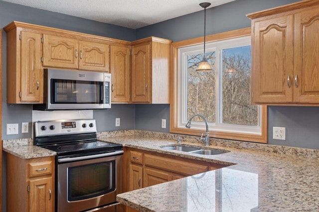 kitchen featuring a sink, pendant lighting, a wealth of natural light, and stainless steel appliances