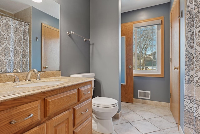 bathroom with vanity, baseboards, visible vents, tile patterned floors, and toilet