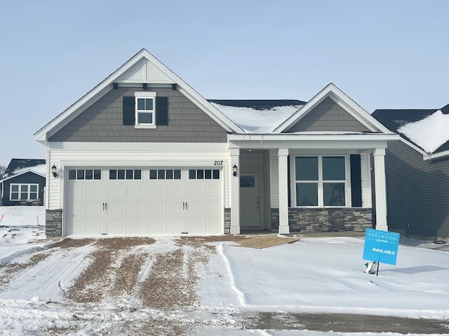 view of front of house featuring a garage, stone siding, and driveway