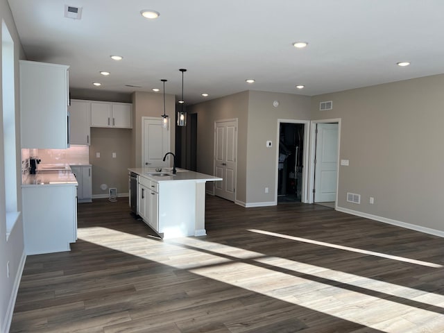 kitchen with white cabinetry, visible vents, dark wood-style flooring, and a sink