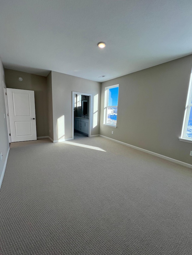 unfurnished living room featuring baseboards and light colored carpet