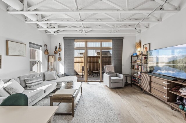 living area featuring coffered ceiling, beamed ceiling, and wood finished floors