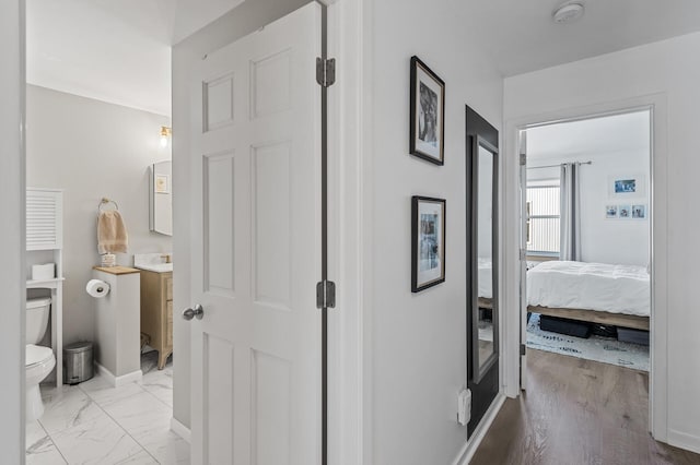 hallway with marble finish floor and baseboards