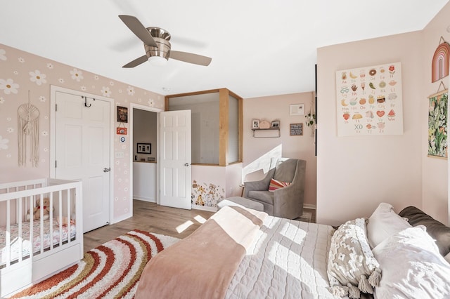 bedroom with a ceiling fan, baseboards, and wood finished floors