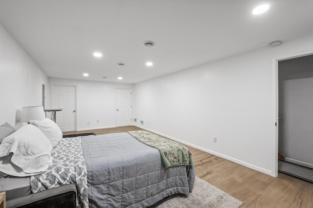 bedroom with light wood-style flooring, baseboards, and recessed lighting