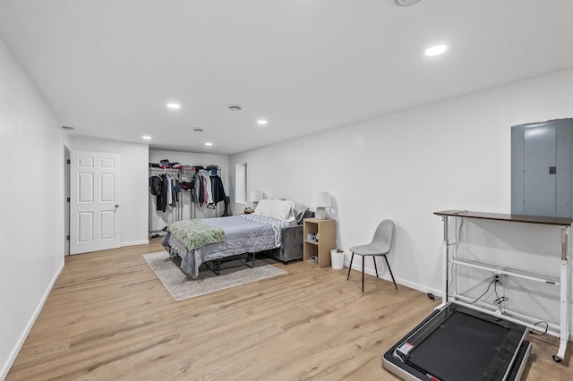 bedroom featuring electric panel, wood finished floors, and recessed lighting