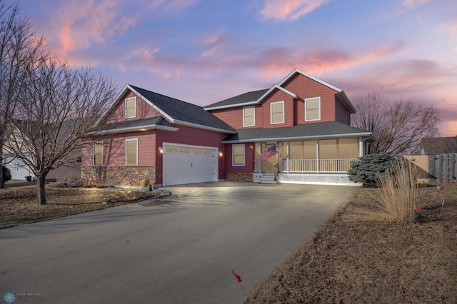 view of front facade with a porch, driveway, a shingled roof, and a garage