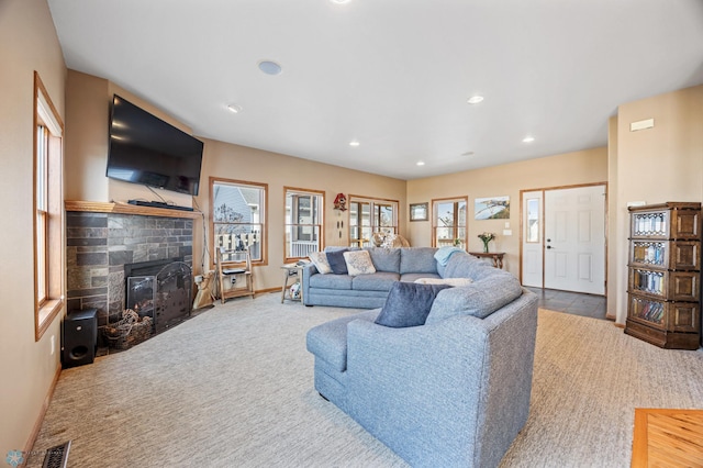 carpeted living area with recessed lighting, visible vents, baseboards, and a fireplace