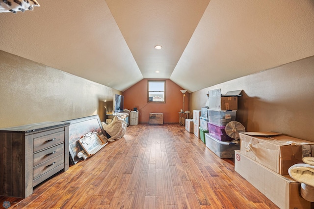 bonus room with hardwood / wood-style floors and vaulted ceiling