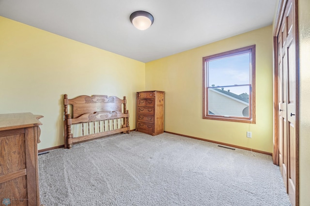 unfurnished bedroom with carpet flooring, baseboards, and visible vents