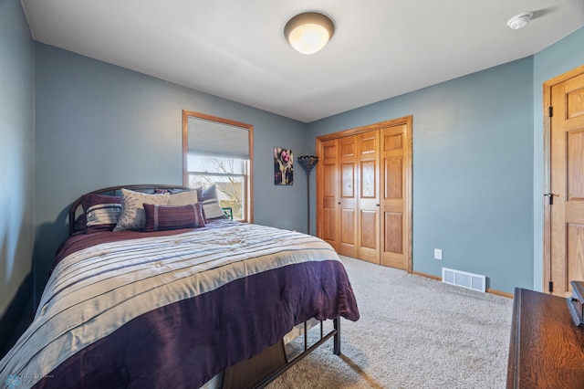 carpeted bedroom featuring visible vents, baseboards, and a closet