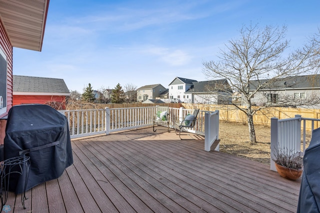 deck featuring a residential view, a grill, and a fenced backyard