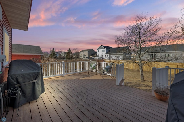 wooden terrace featuring grilling area, a residential view, and a fenced backyard