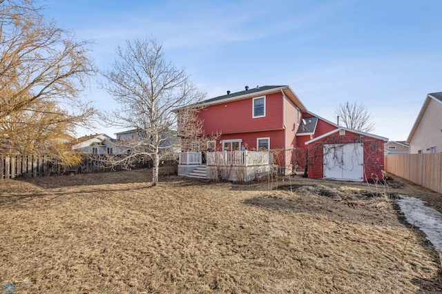 rear view of house featuring a wooden deck and a fenced backyard