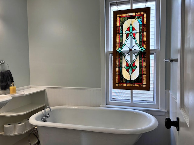 bathroom featuring wainscoting and a freestanding tub