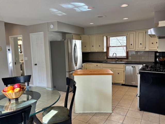 kitchen featuring light tile patterned flooring, tasteful backsplash, appliances with stainless steel finishes, and a sink